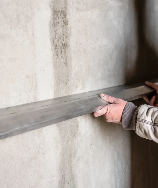 construction-worker-plastering-wall-with-leveler