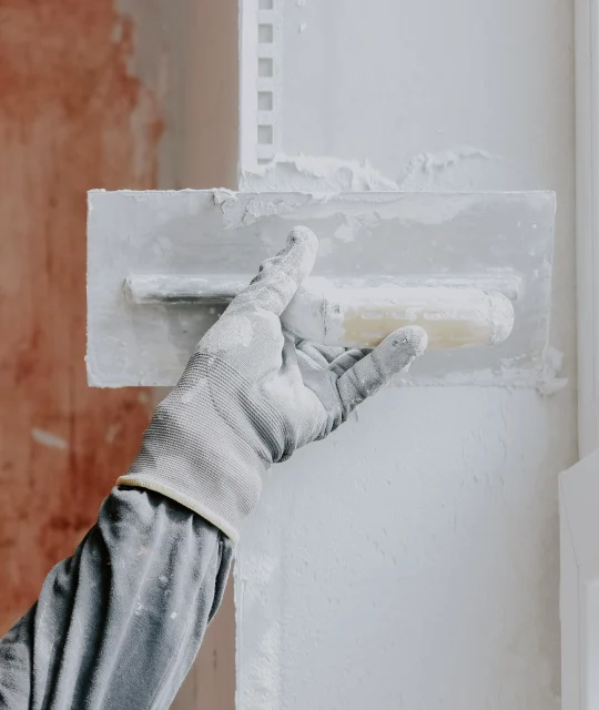 one-hand-construction-glove-plasterer-applies-fresh-putty-window-opening-with-spatula