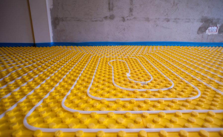 yellow underfloor heating installation with white polyethylene pipes on construction site of new two level apartment